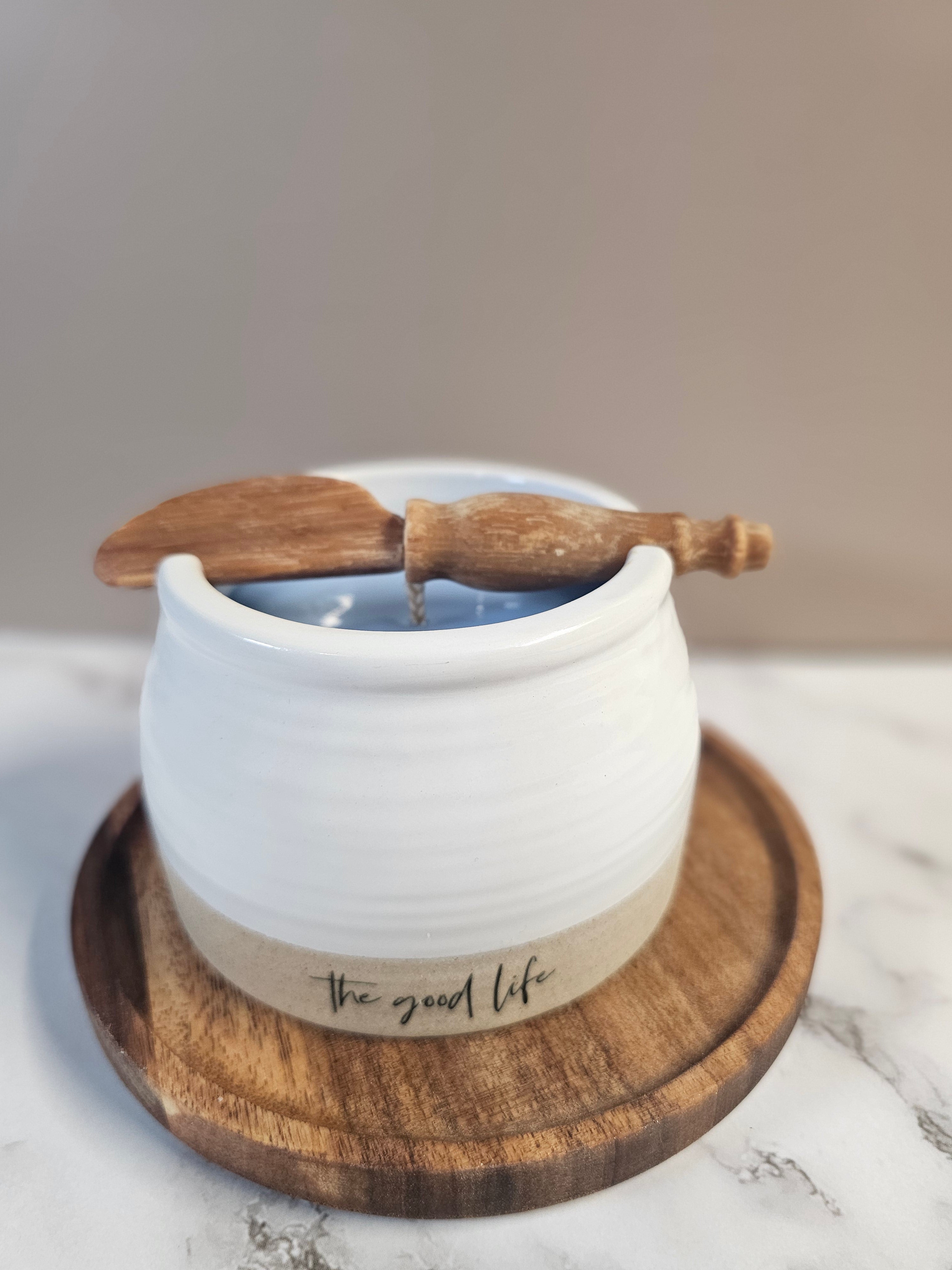 White ceramic pot filled with blueberry mornings candle sitting on a wood tray