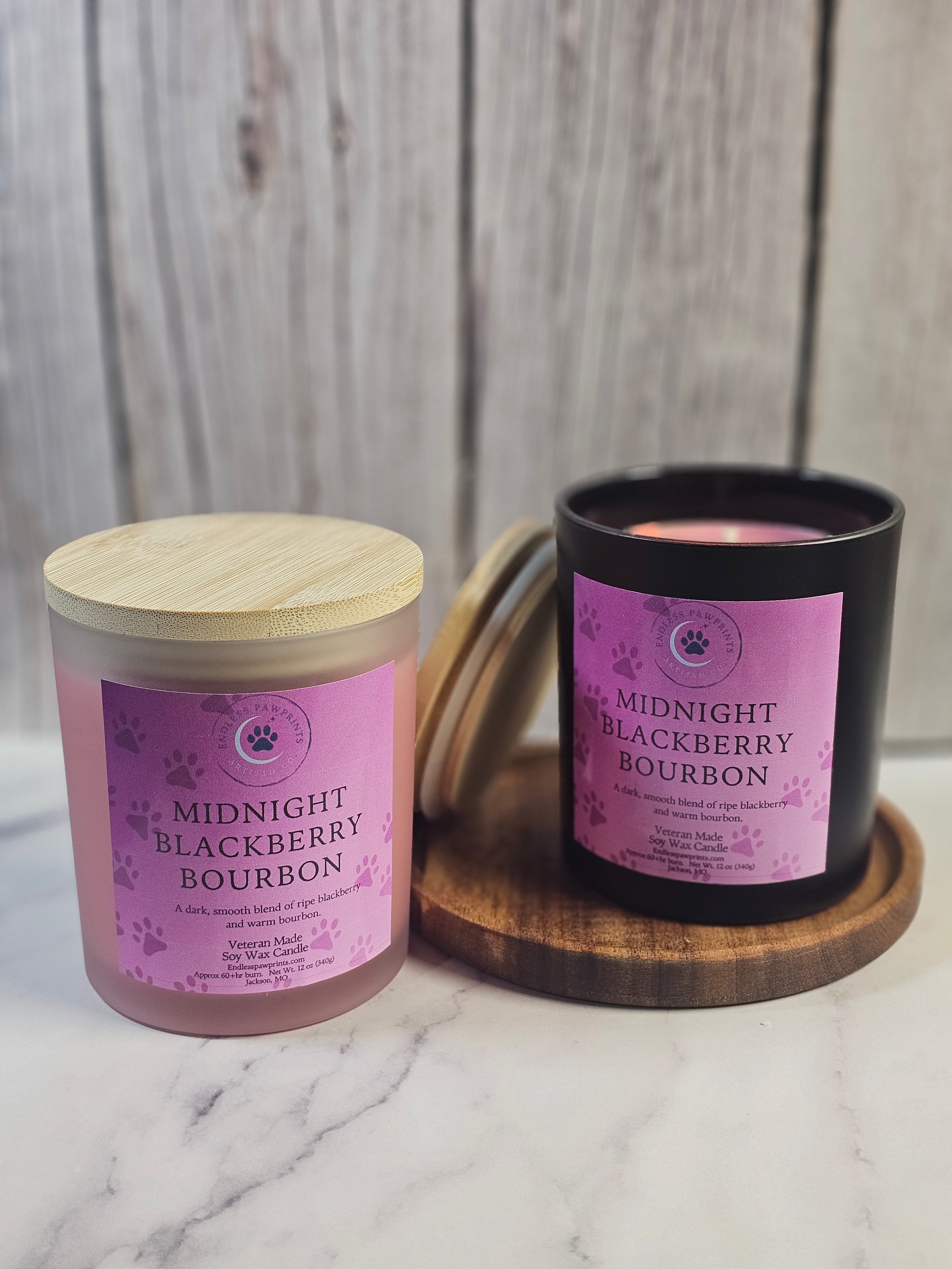 two midnight blackberry bourbon candles sitting in front of a wooden background on a wooden tray

