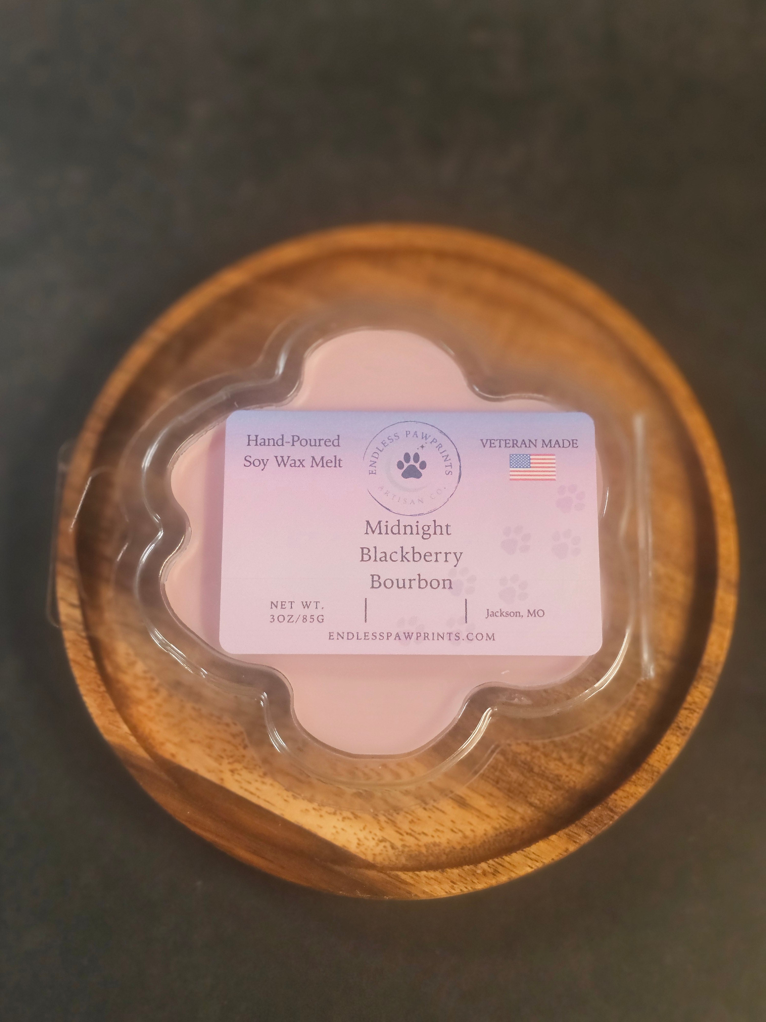 Midnight blackberry bourbon wax melt in a paw print clam shell
