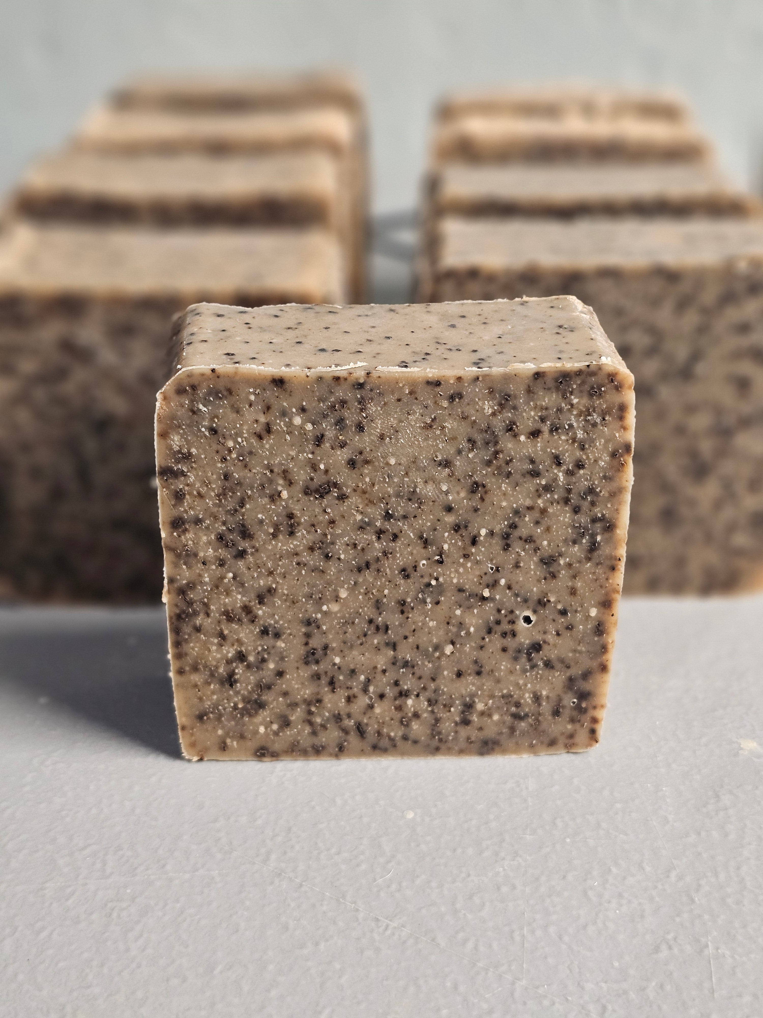 Close-up of a textured brown coffee soap bar on a gray background