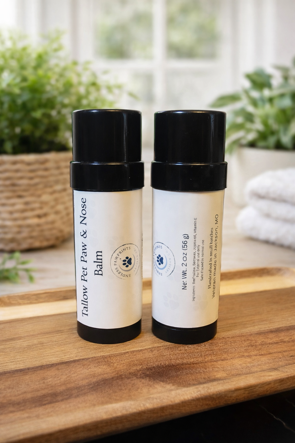 Two bottles of pet nose and paw balm on a wooden surface with plants in the background