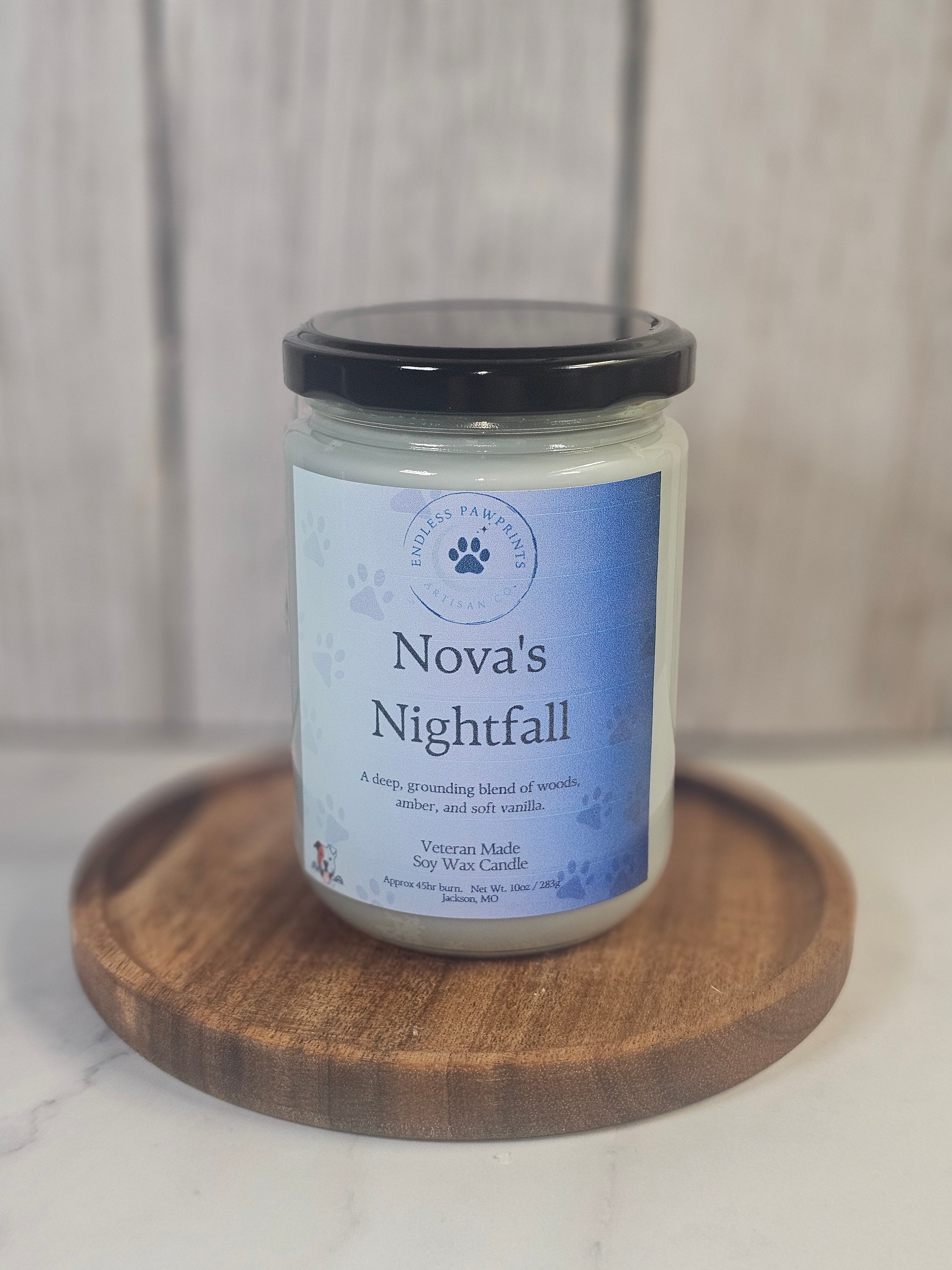 Jar of 'Novas Nightfall' candle on a wooden stand with a light background
