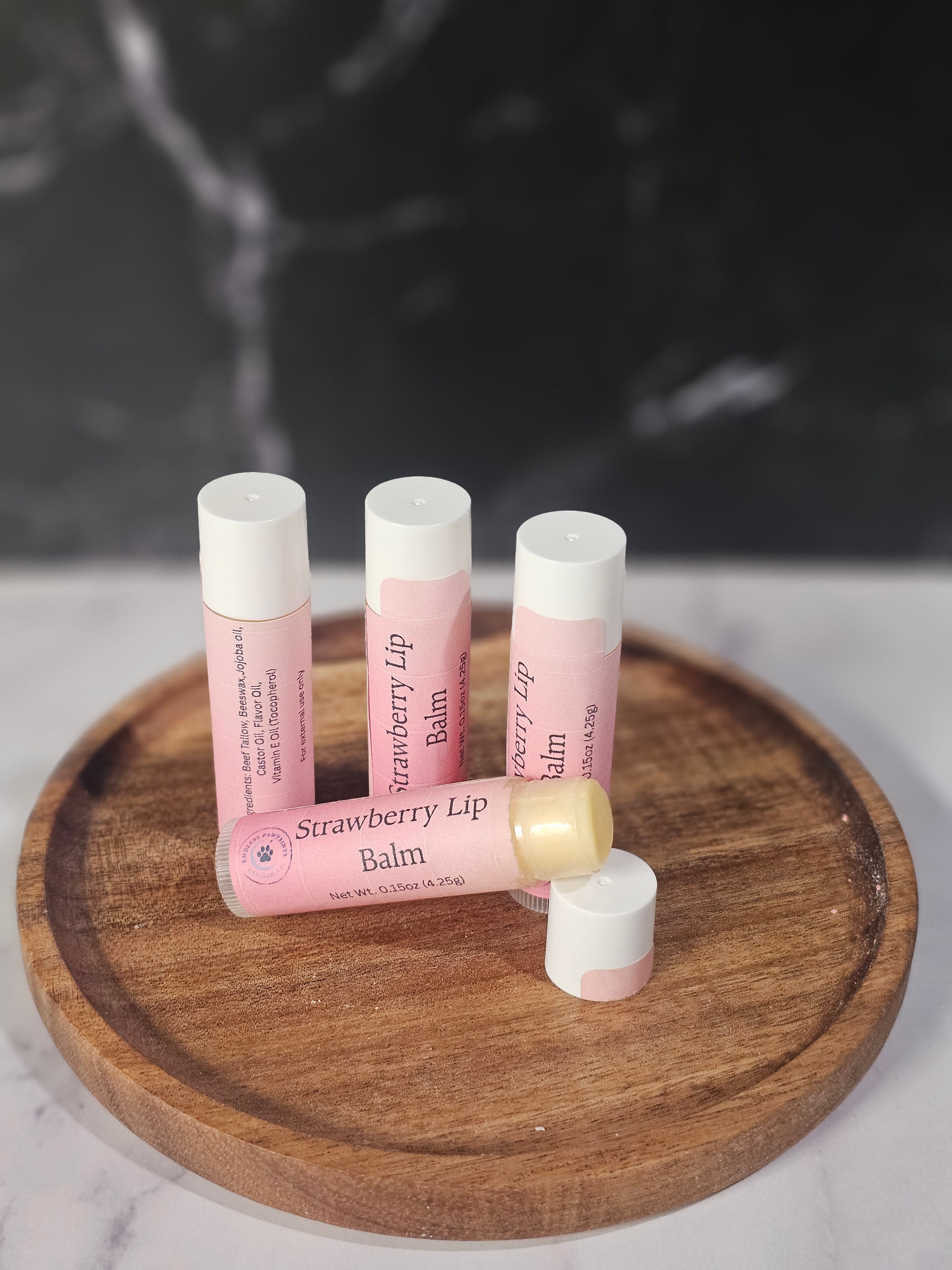 Strawberry lip balm on a wooden surface with a blurred background
